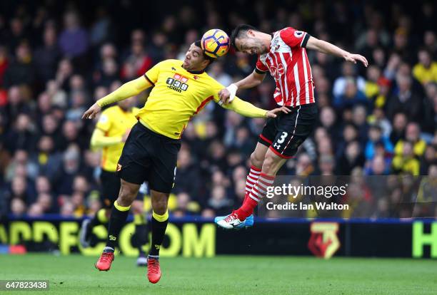 Troy Deeney of Watford and Maya Yoshida of Southampton battle to win a header during the Premier League match between Watford and Southampton at...