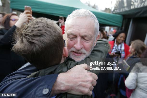 British main opposition Labour Party leader Jeremy Corbyn embraces a supporter as he attends a rally against private companies' involvement in the...