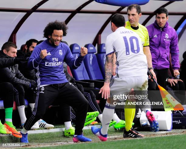 Real Madrid's Colombian midfielder James Rodriguez celebrates with teammate Brazilian defender Marcelo after scoring their team's third goal during...