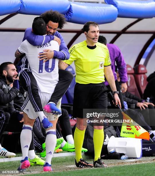 Real Madrid's Colombian midfielder James Rodriguez celebrates with teammate Brazilian defender Marcelo after scoring their team's third goal during...