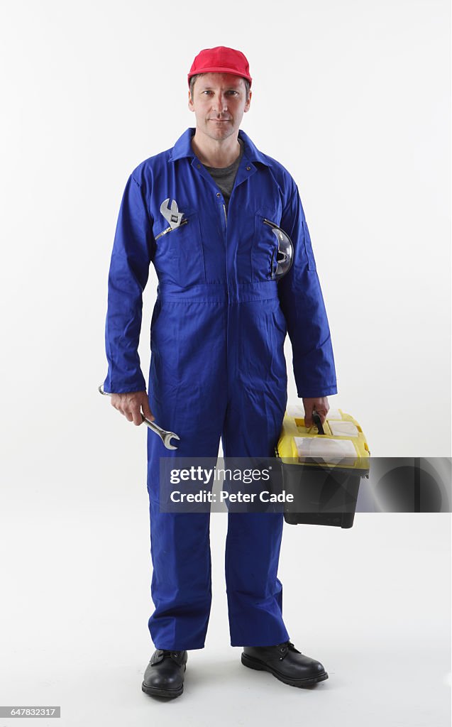 Workman stood holding tools