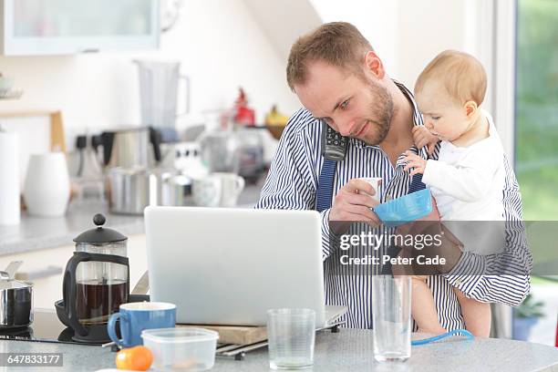 father with baby before work in kitchen - multitasking man stock pictures, royalty-free photos & images