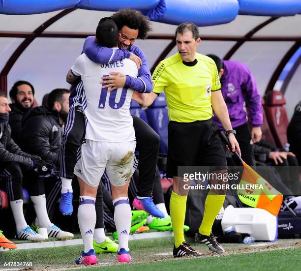 Real Madrid's Colombian midfielder James Rodriguez celebrates with teammate Brazilian defender Marcelo after scoring their team's third goal during...