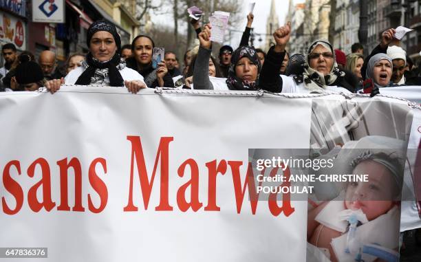 Women hold a banner and shout slogans on March 4, 2017 in Marseille, southern France during a march to show support to Marwa, a 15-month-old heavily...