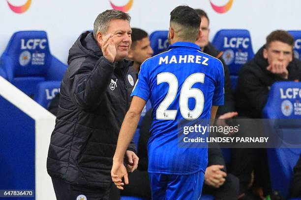 Leicester City's Algerian midfielder Riyad Mahrez celebrates with Leicester City's English interim manager Craig Shakespeare after scoring their...