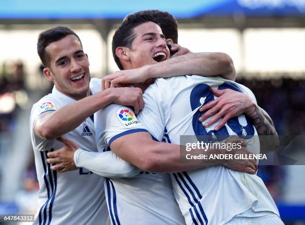 Real Madrid's midfielder Marco Asensio Willemsen celebrates with teammates forward Lucas Vazquez and Colombian midfielder James Rodriguez after...