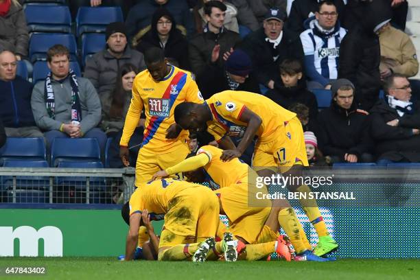 Crystal Palace's English midfielder Andros Townsend is congratulated by teammates after scoring their second goal during the English Premier League...