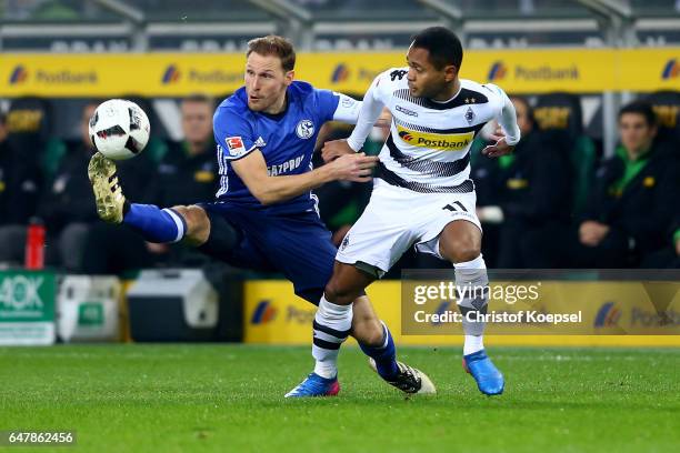 Benedikt Hoewedes of Schalke challenges Raffael of Moenchengladbach during the Bundesliga match between Borussia Moenchengladbach and FC Schalke 04...