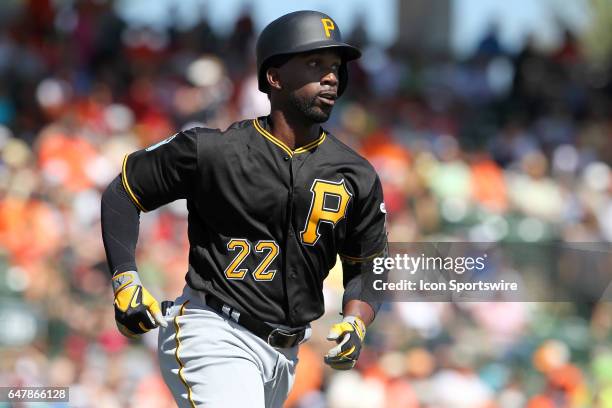 Andrew McCutchen of the Pirates lines a pitch to the outfield for a hit and then hustles down the line to first base during the spring training game...