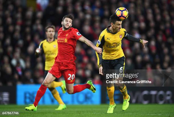 Adam Lallana of Liverpool puts pressure on Laurent Koscielny of Arsenal during the Premier League match between Liverpool and Arsenal at Anfield on...