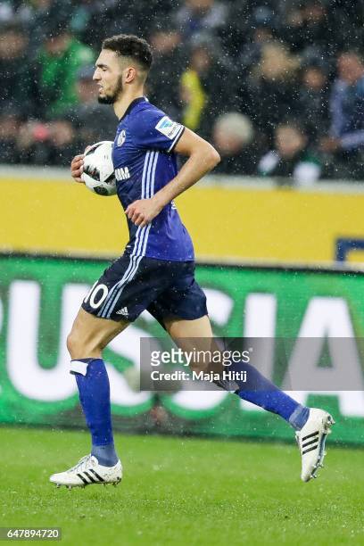 Nabil Bentaleb of Schalke holds the ball after scoring 11-meter penalty shot to make it 1-1 during the Bundesliga match between Borussia...