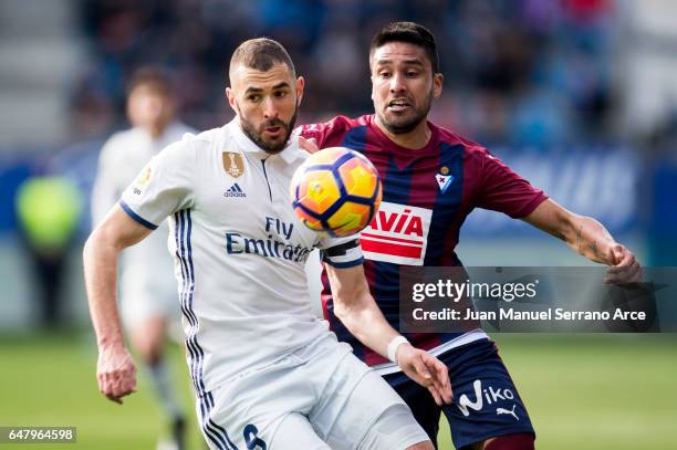 Karim Benzema of Real Madrid duels for the ball with Mauro Javier Dos Santos of SD Eibar during the La Liga match between SD Eibar and Real Madrid at...