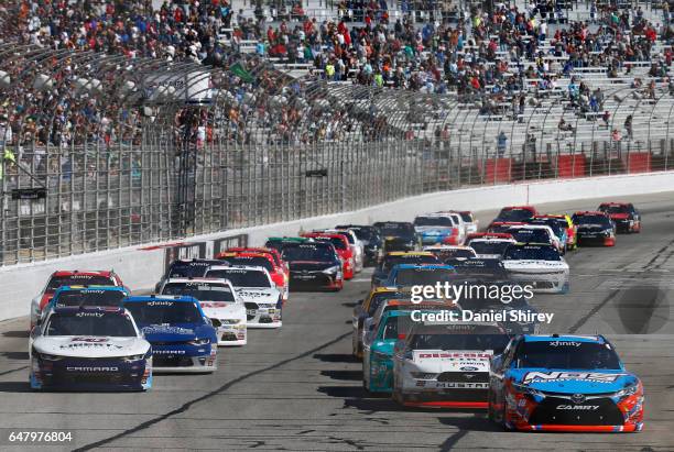 Kyle Busch, driver of the NOS Energy Drink Toyota, and William Byron, driver of the Liberty University Chevrolet, lead the field during the start of...