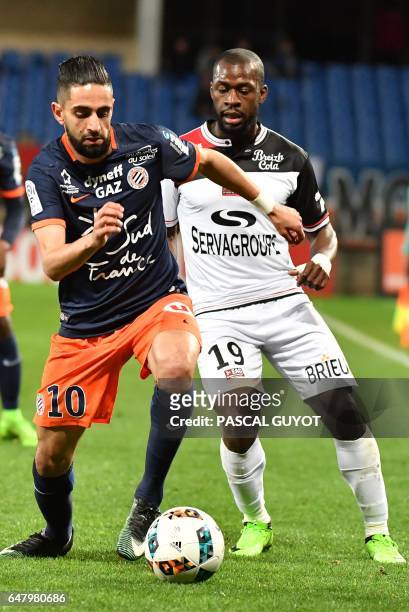 Montpellier's French midfielder Ryad Boudebouz vies with Guingamp's French midfielder Yannis Salibur during the French L1 football match between MHSC...