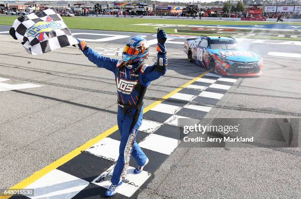 Kyle Busch, driver of the NOS Energy Drink Toyota, celebrates with the checkered flag after winning the NASCAR XFINITY Series Rinnai 250 at Atlanta...