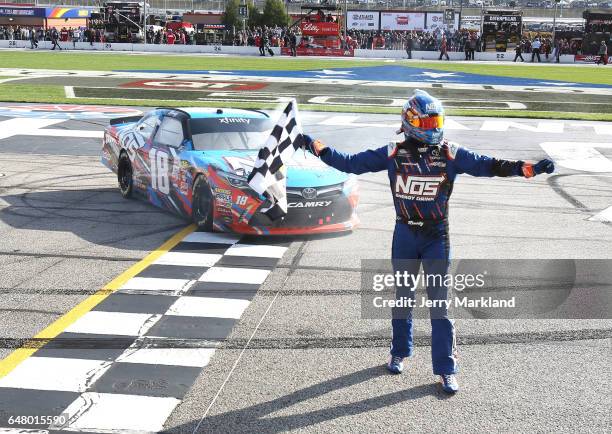 Kyle Busch, driver of the NOS Energy Drink Toyota, celebrates with the checkered flag after winning the NASCAR XFINITY Series Rinnai 250 at Atlanta...