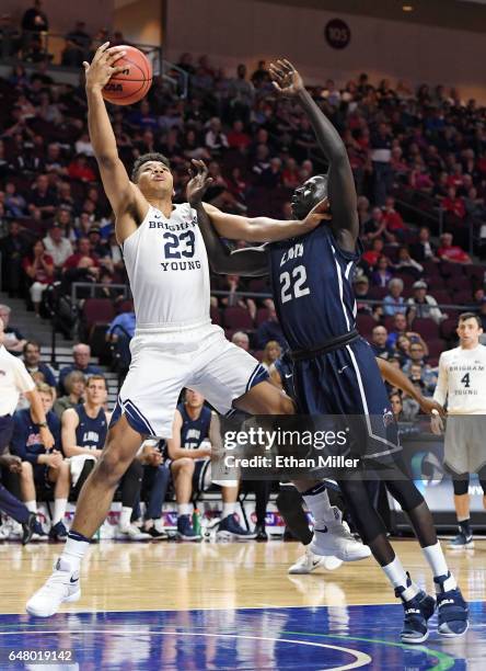 Yoeli Childs of the Brigham Young Cougars and Buay Tuach of the Loyola Marymount Lions go after a loose ball during a quarterfinal game of the West...