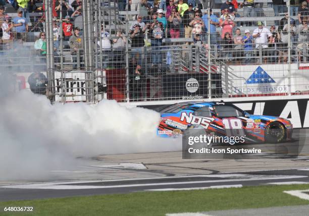 Victorious Kyle Busch Joe Gibbs Racing NOS Energy Toyota Camry celebrates with a burnout after winning the Xfinity Series Rinnai 250 on March 04 at...