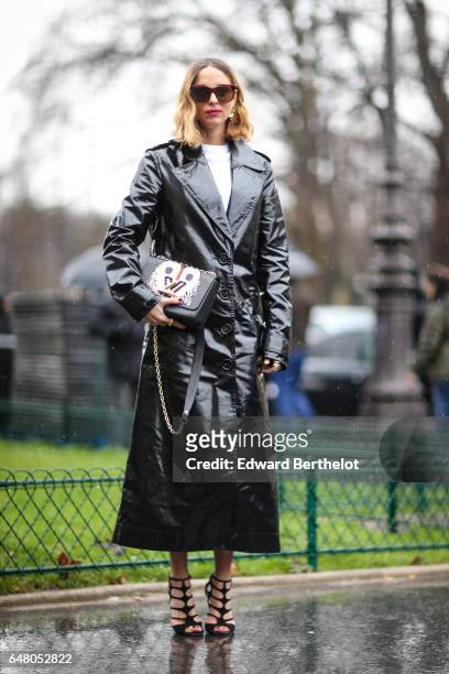 Candela Novembre is wearing a black trench coat, a Louis Vuitton bag, sunglasses, and heels, outside the Elie Saab show, during Paris Fashion Week...