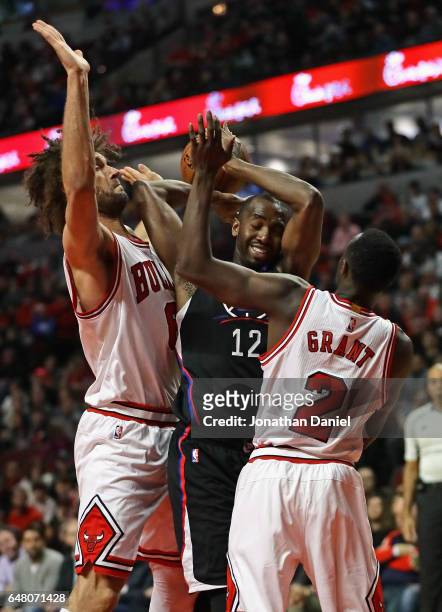 Luc Mbah a Moute of the LA Clippers tries to get off a shot between Robin Lopez and Jerian Grant of the Chicago Bulls at the United Center on March...