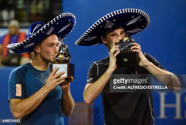 Tennis player Jamie Murray and Brazilian tennis player Bruno Soares kiss their trophies after winning the Mexican Tennis Open doubles final match...