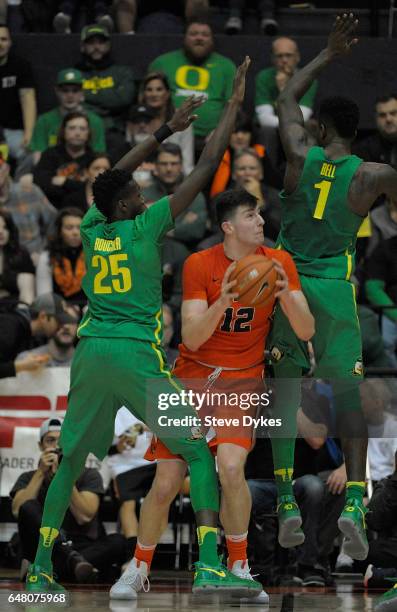 Drew Eubanks of the Oregon State Beavers tries to get around Chris Boucher and Jordan Bell of the Oregon Ducks during the second half of the game at...