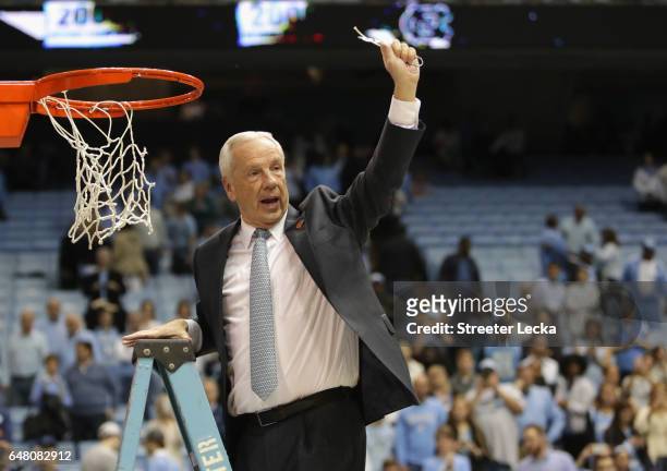 Head coach Roy Williams of the North Carolina Tar Heels celebrates as he cuts down the net after defeating the Duke Blue Devils 90-83 to clinch the...