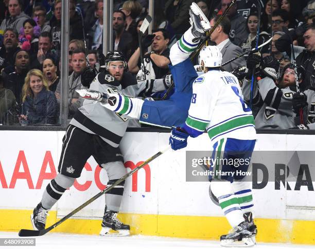 Andy Andreoff of the Los Angeles Kings knocks Jayson Megna of the Vancouver Canucks over the boards during the second period at Staples Center on...