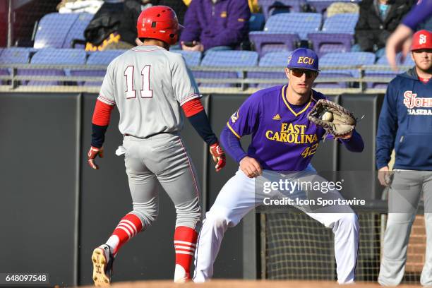 St. John's infielder John Valente gets back to first base before East Carolina outfielder Spencer Brickhouse can pick him off in a game between the...