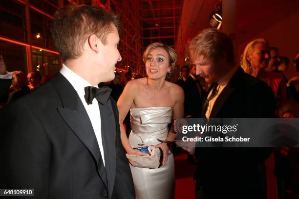 Singer James Blunt, Caren Miosga, looks for a pen for an autograph of singer Ed Sheeran during the Goldene Kamera reception at Messe Hamburg on March...