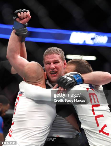 Middleweight Daniel Kelly of Australia celebrates with members of his team after he is declared the winner by split decision over Rashan Evans during...