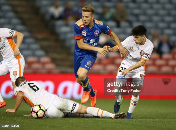 Andrew Hoole of the Jets contests the ball with Joe Caletti of the Roar during the round 22 A-League match between the Newcastle Jets and the...