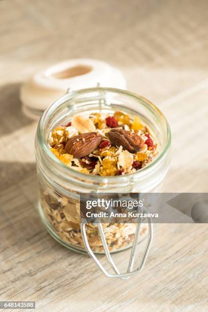 homemade muesli with oat flakes, dried fruits and nuts in a jar, selective focus - raisin bran stock pictures, royalty-free photos & images