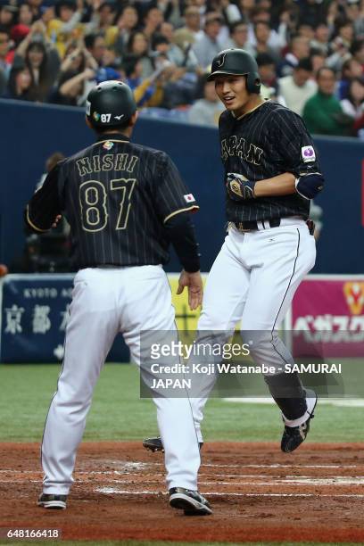 Outfielder Seiya Suzuki of Japan is welcomed by coach Toshihisa Nishi after hitting a three-run homer in the top of the second inning during the...