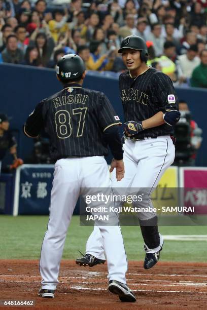 Outfielder Seiya Suzuki of Japan is welcomed by coach Toshihisa Nishi after hitting a three-run homer in the top of the second inning during the...