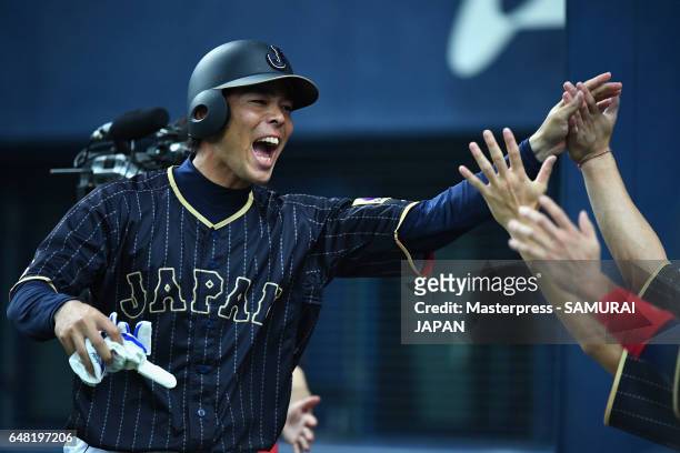 Pinch hitter Shogo Akiyama of Japan high fives with his team mates after hitting a two-run triple after the top of the ninth inning during the World...
