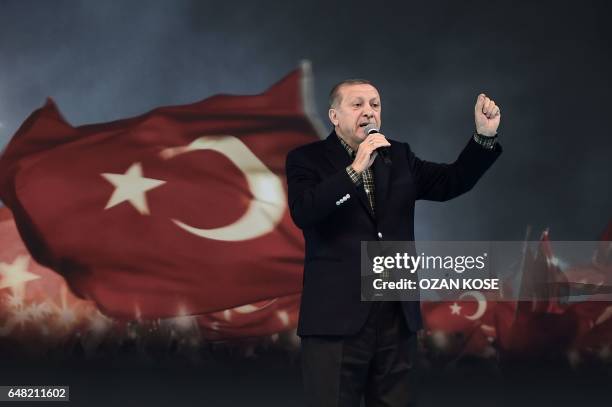 Turkish President Recep Tayyip Erdogan gestures as he delivers a speech on stage, on March 5, 2017 in Istanbul during a pro-government women meeting....