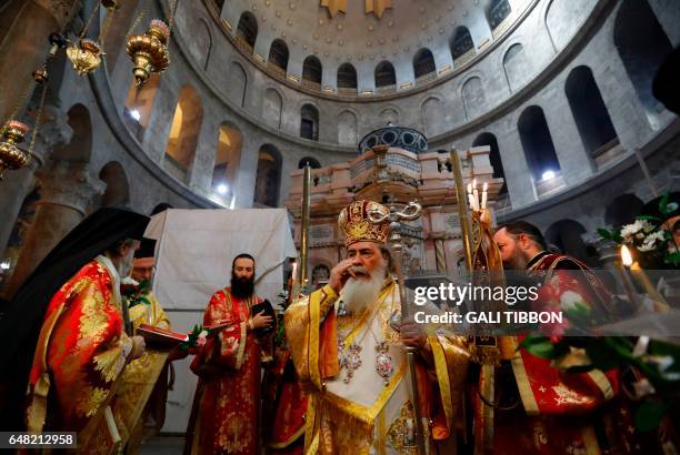 Greek Orthodox Patriarch of Jerusalem Theophilos III prays infront of the Edicule at the Church of the Holy Sepulchre in Jerusalems old city during...