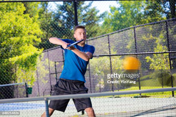 ragazzo adolescente che gioca a palla sottaceto - paddle tennis foto e immagini stock