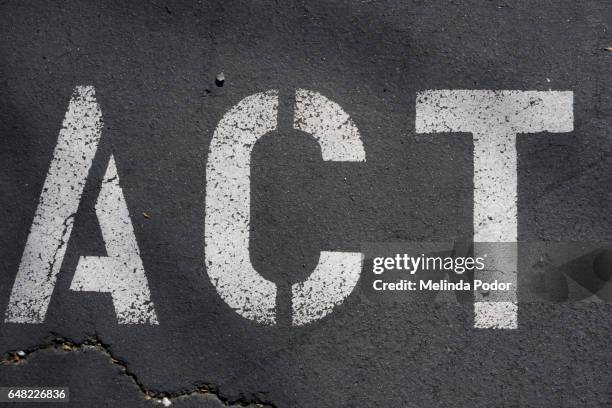 the word "act" painted on asphalt - encouragement words stock pictures, royalty-free photos & images