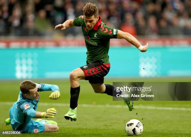 Florian Niederlechner of Freiburg on his way to score his teams first goal against goalkeeper Lukas Hradecky of Frankfurt during the Bundesliga match...