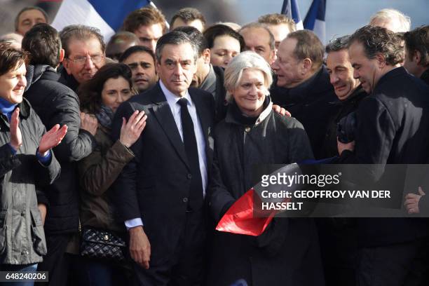 French presidential election candidate for the right-wing Les Republicains party Francois Fillon holds by the shoulder his wife Penelope Fillon and...