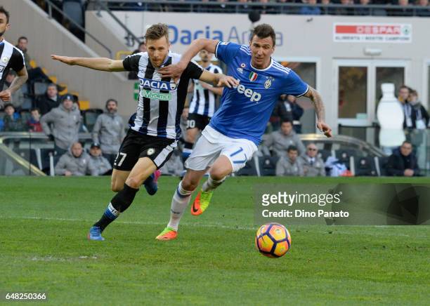Silvan Widmer of Udinese Calcio competes with Mario Mandzukic of Juventus FC during the Serie A match between Udinese Calcio and Juventus FC at...