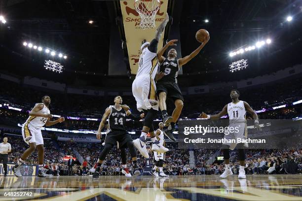 Tony Parker of the San Antonio Spurs shoots against DeMarcus Cousins of the New Orleans Pelicans during the first half of a game at the Smoothie King...