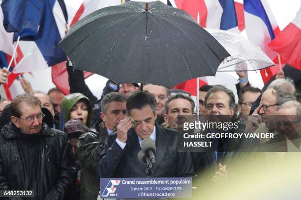 French presidential election candidate for the right-wing Les Republicains party Francois Fillon dries his face with a handkerchief as he delivers a...