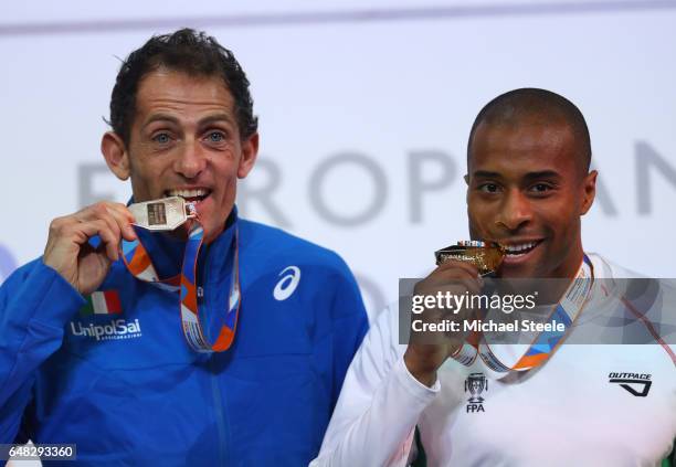 Silver medalist Fabrizio Donato of Italy and gold medalist Evora Nelson of Portugal pose during the medal ceremony for the Men's Triple Jump on day...