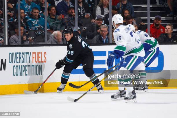 Michael Haley of the San Jose Sharks skates with the puck against Joseph Cramarossa of the Vancouver Canucks at SAP Center on March 2, 2017 in San...