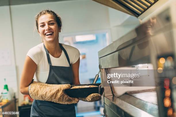 beautiful baker holding hot bread - baking bread stock pictures, royalty-free photos & images