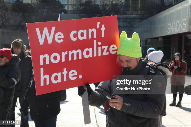 Pro-Muslim protestor carrying a sign saying 'We Can't Normalize Hate' as opposing groups of protesters clashed over the M-103 motion to fight...