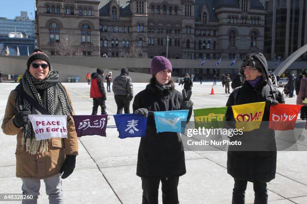 Pro-Muslim demonstrators hold flags with the word 'Peace' in several languages during a counter-protest against anti-Muslim groups over the M-103...